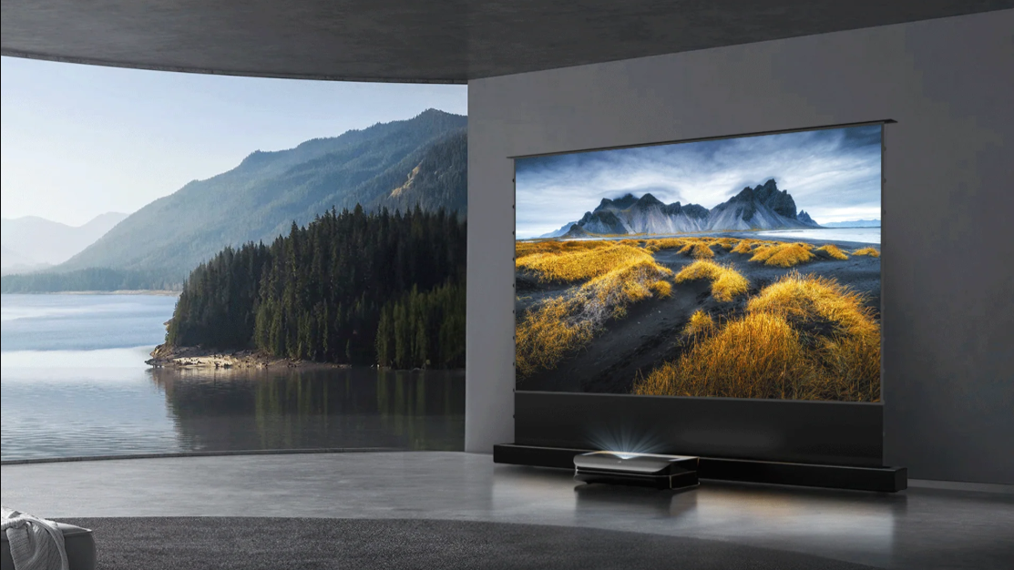 A 4K ultra-short-throw projector displays a crisp, colorful landscape on a large screen in a modern room with a view of a lake and mountains.